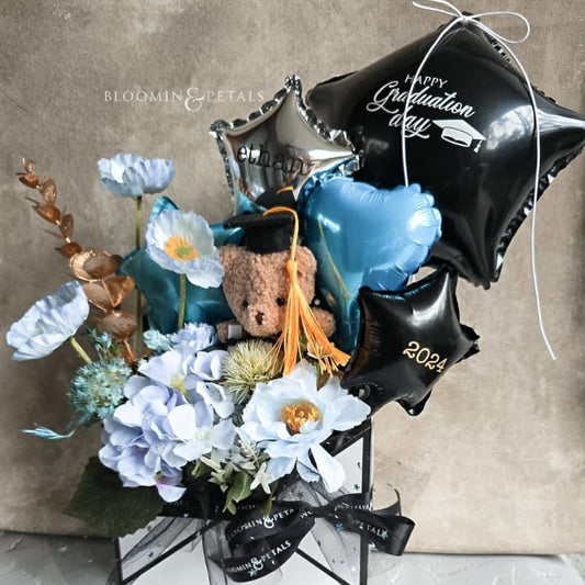 Envelope box floral arrangement with cute graduation teddy bear and foil balloons